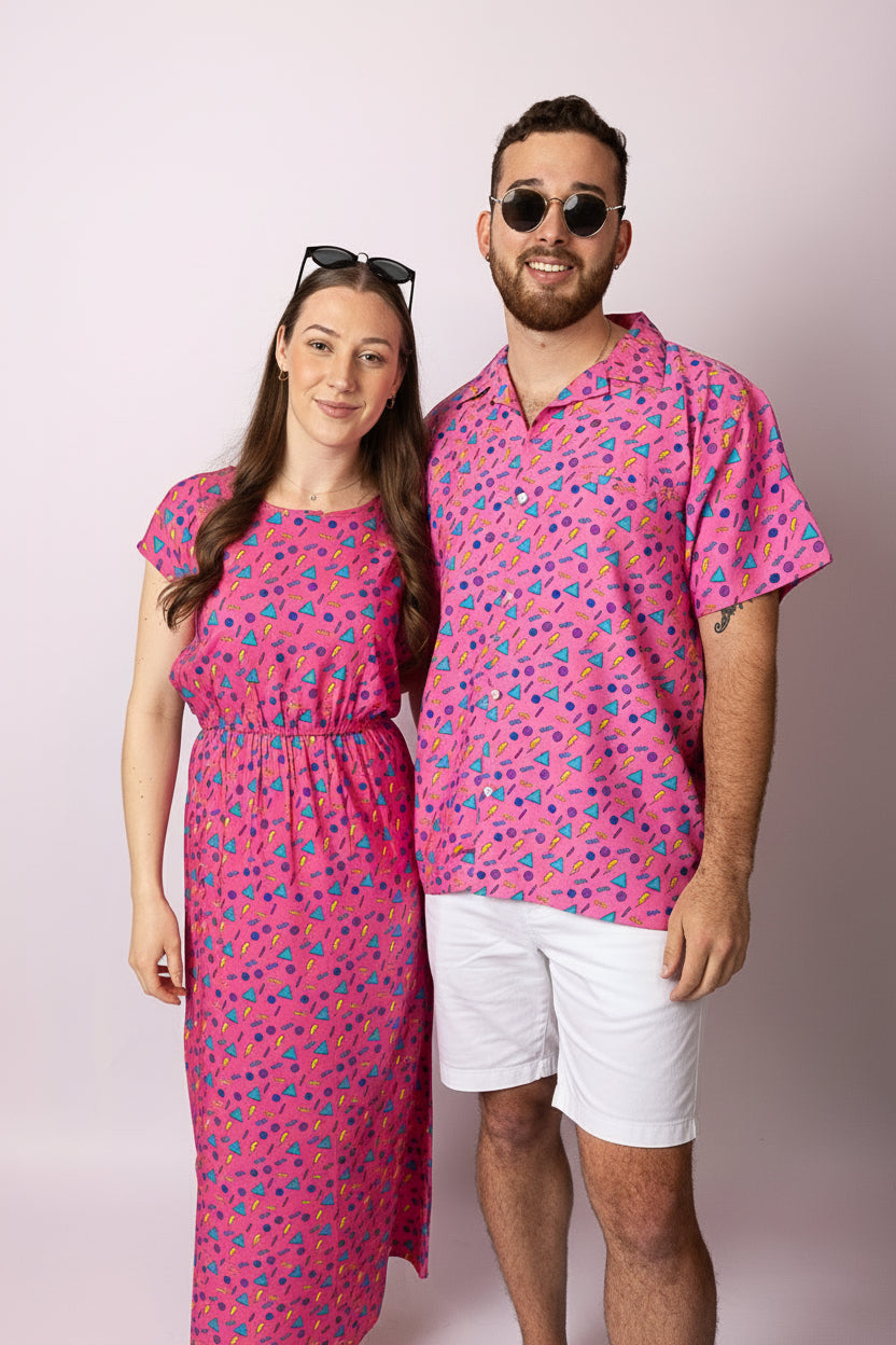 Two people wearing matching pink outfits with a pattern on a plain background