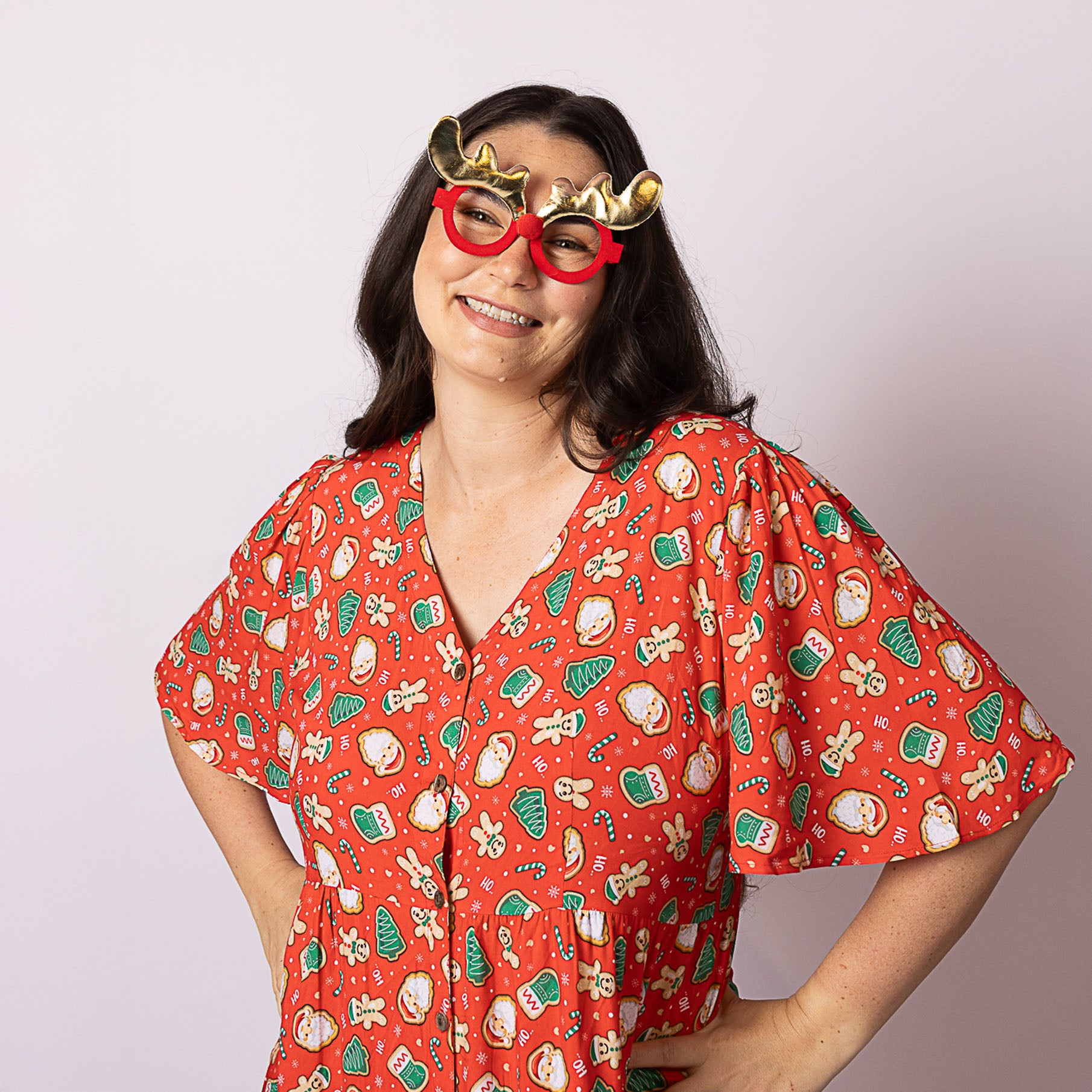 Portrait of a woman wearing the Alice Gingerbread Jest Christmas dress, highlighting the fun gingerbread and holiday icons on the fabric.