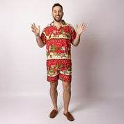 A man wearing the Tropicool Happy Santa Red adult Christmas shirt, smiling in a playful pose with a Santa hat. Fun Aussie festive outfit perfect for parties, summer events, and matching family looks.