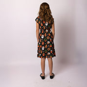 Back view of the Holly Jingleverse Christmas Kids Dress, showing the colourful festive rick and morty  print and comfortable fit