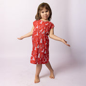Girl wearing the Tropicool Holly Reindeer Red Kids Dress with a Christmas headband, arms out in a playful holiday pose.