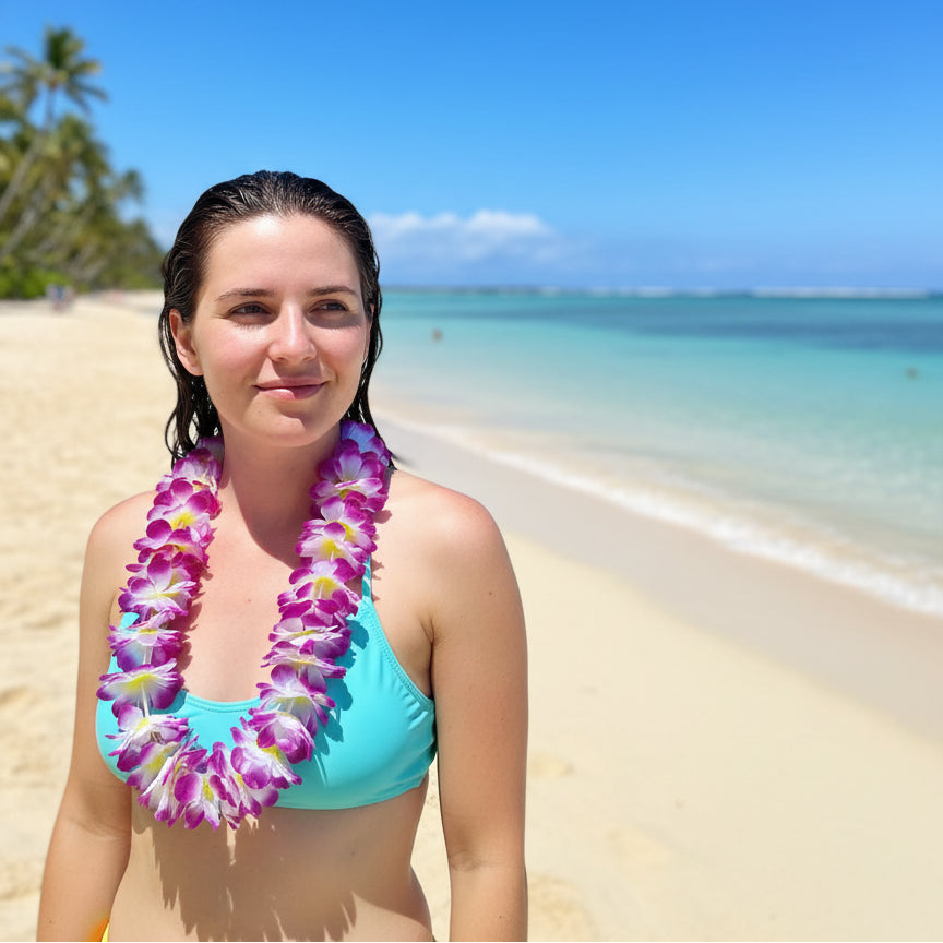 Person wearing swimmers and purple hawaiian flower lei tropical party accessory, on the beach