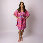 Woman wearing the Tropicool Retro Vibe Kaftan in pink, featuring a relaxed fit and colourful geometric print, perfect for Aussie summer events.